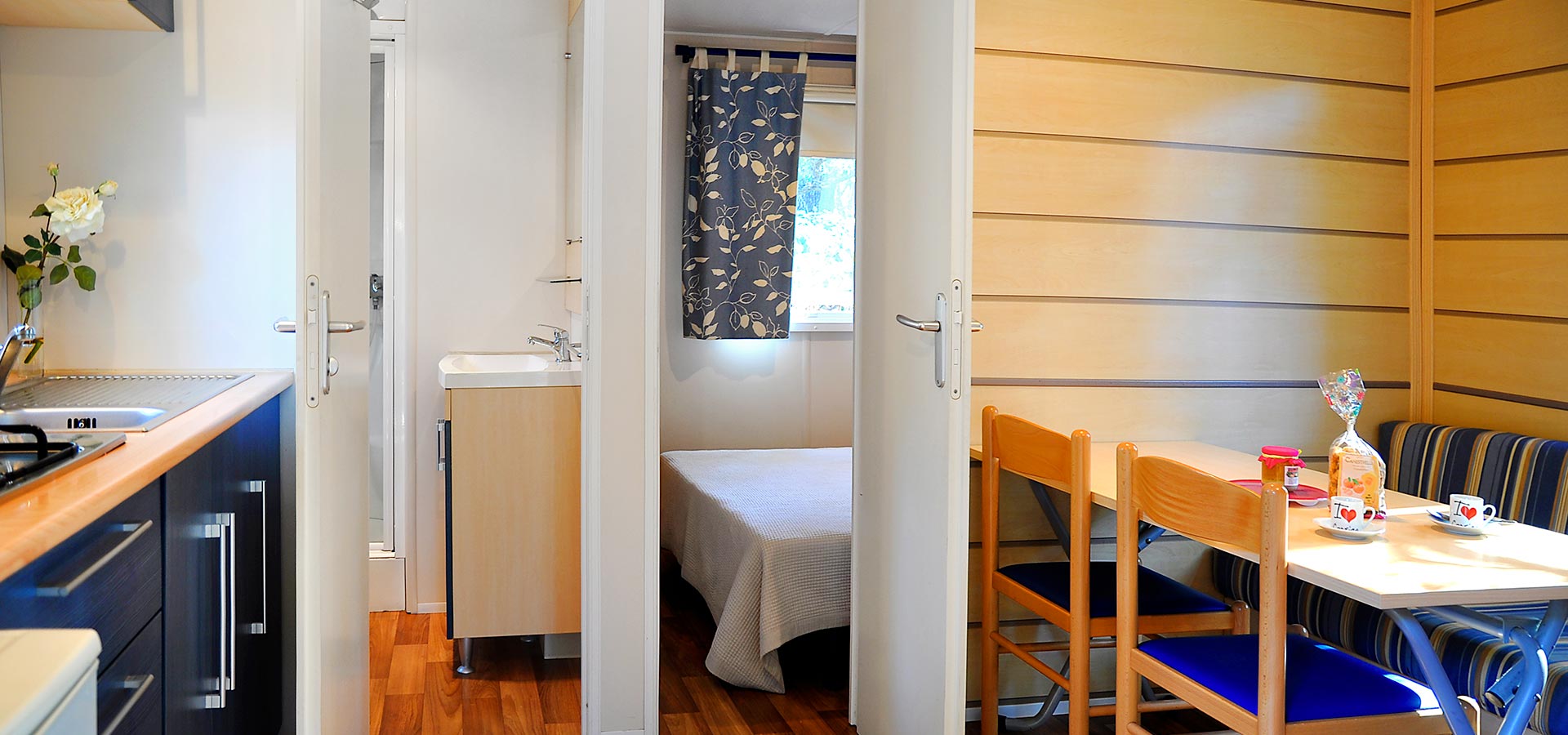 Camping san damiano bungalow astria cuisine salle de bain chambre principale table