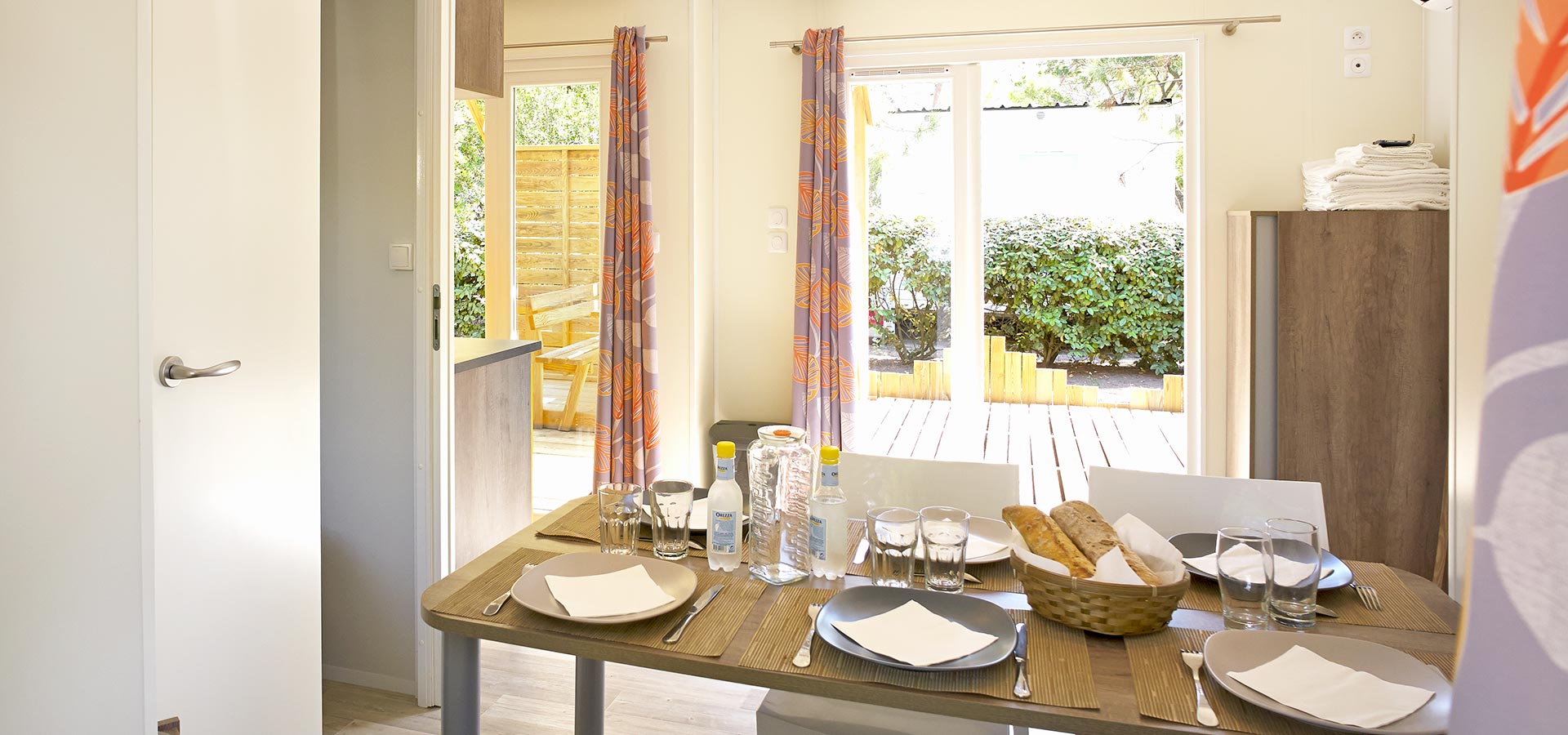 Camping san damiano bungalow Declik table repas salon cuisine terrasse