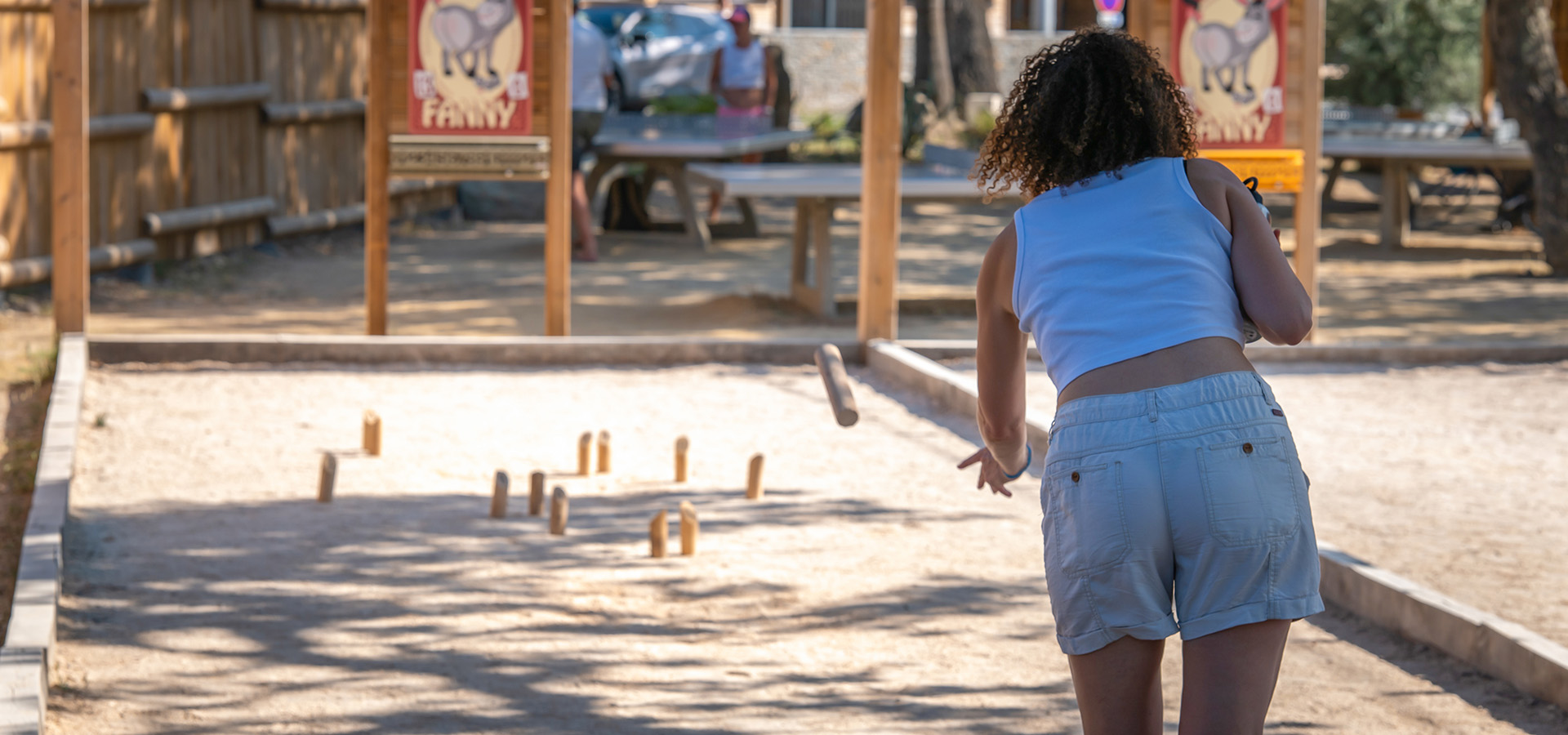 Camping san damiano jeux boulodrome femme qui joue aux quilles finlandaises